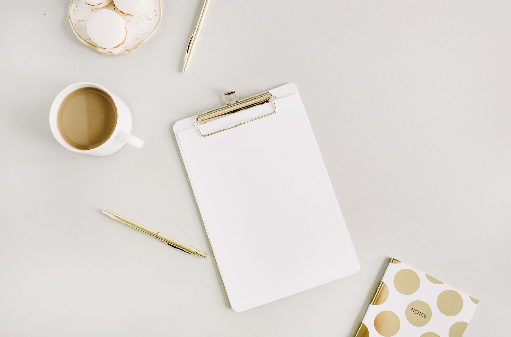 A decorative image including a coffee mug, pen, paper and notebook on a white background thought to match the theme of the article as someone thinking about what kitchen layout they would go after.